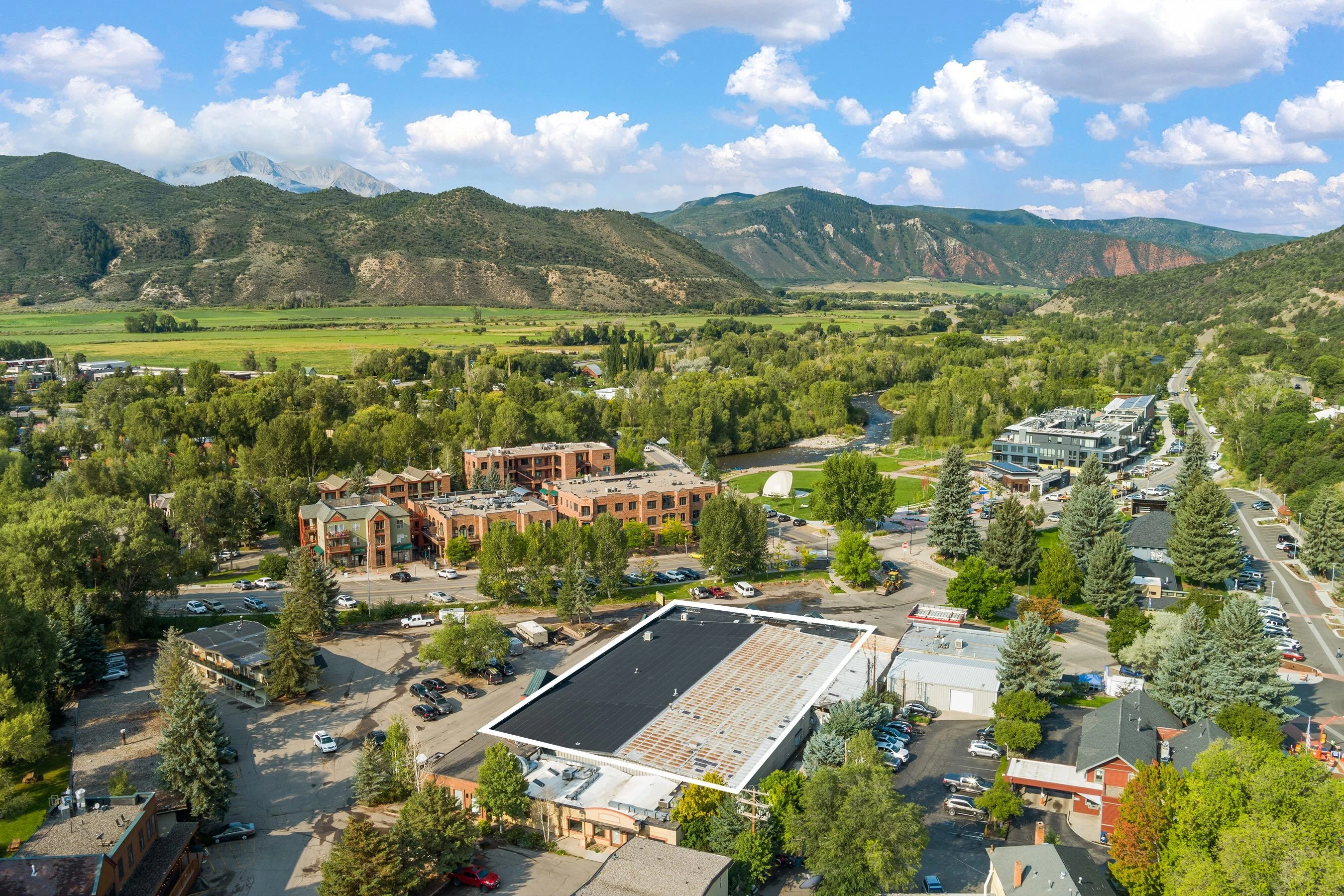 Basalt, Colorado, with riverside buildings, green hills and the surrounding valley