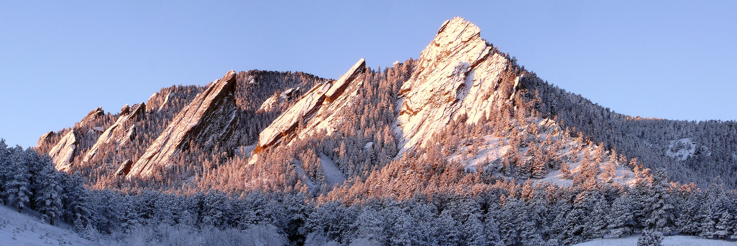 The Flatirons above Boulder, Colorado, with fresh snow in sunrise light