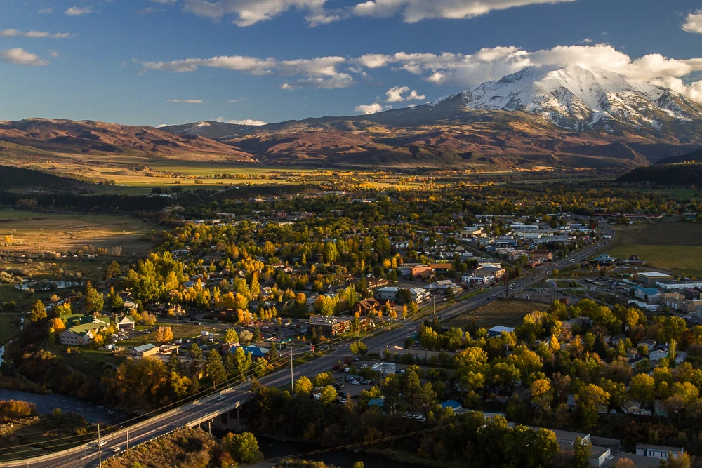 Carbondale, Colorado, surrounded by autumn trees and snow-covered mountains
