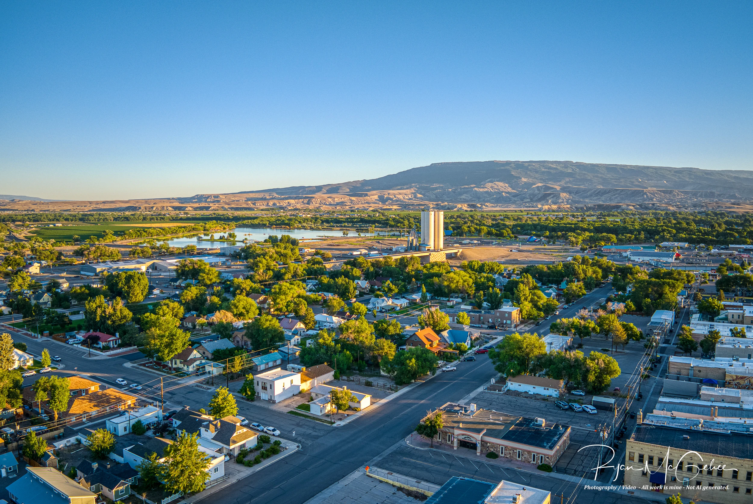 Aerial view of Delta, Colorado, with town streets, trees and the surrounding mesas