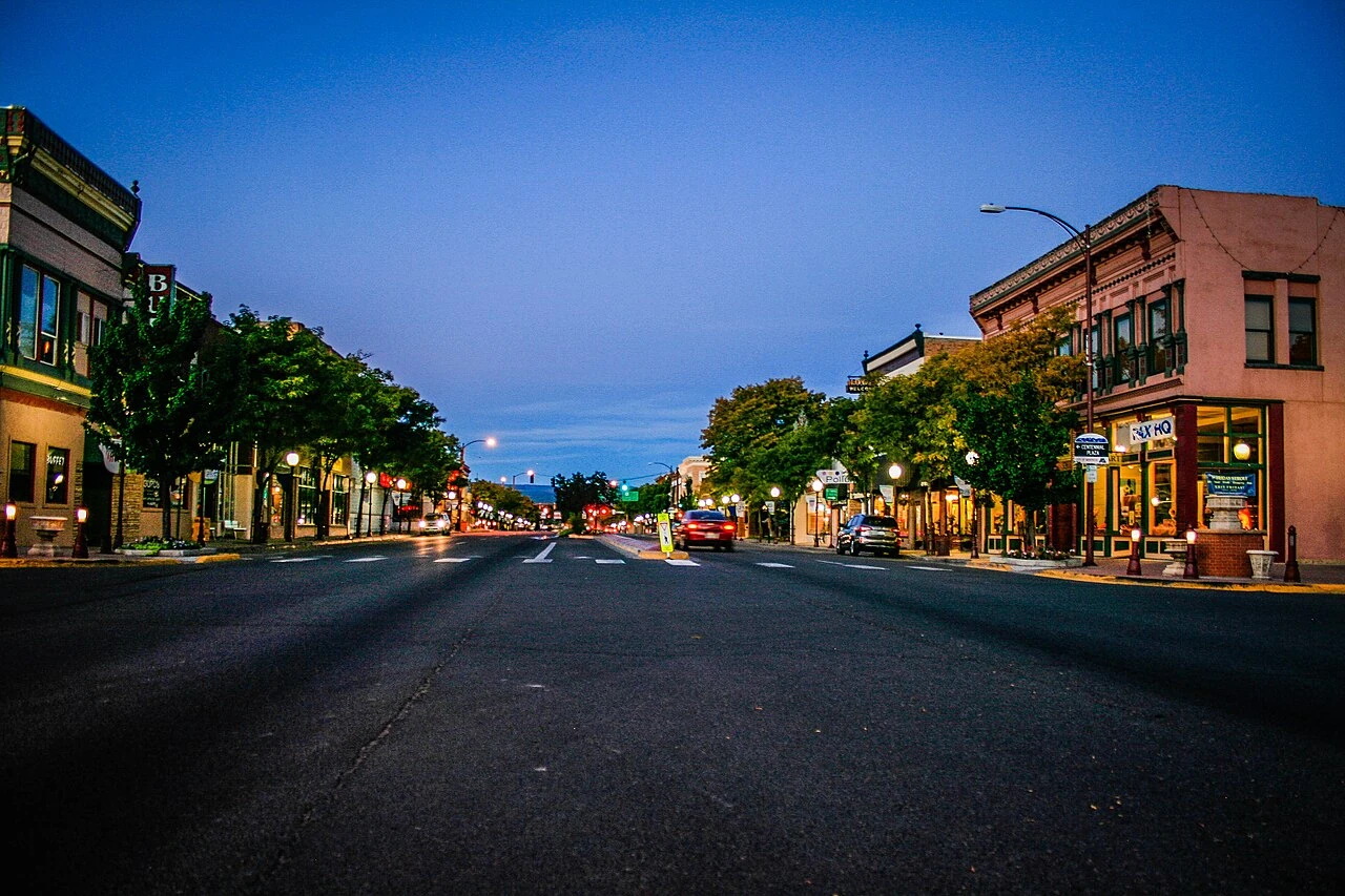 Historic storefronts and tree-lined streets in downtown Montrose, Colorado, at dusk