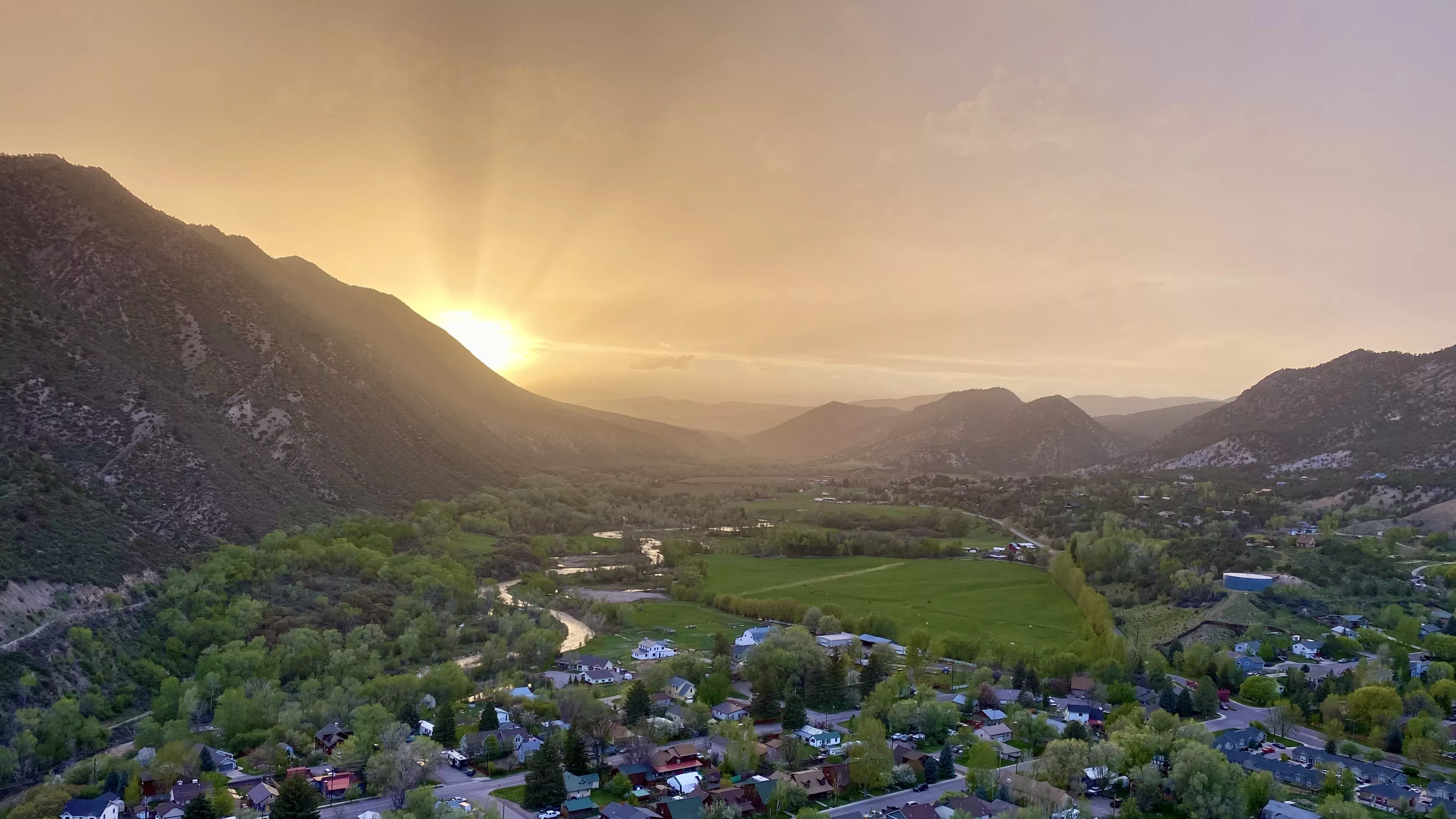 Sunset over New Castle, Colorado, with mountains, homes and the river valley